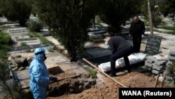 Relatives bury journalist Abdollah Zavieh, who passed away due to coronavirus disease (COVID-19), at Behesht Zahra cemetery in Tehran, March 24, 2020