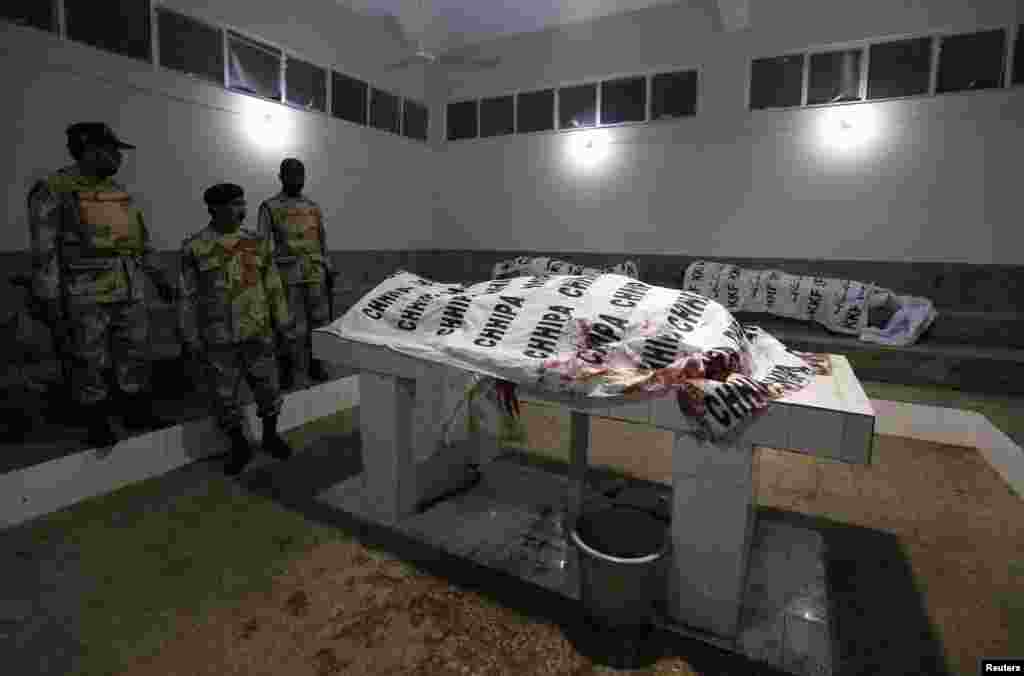 Soldiers from the Pakistani Rangers force stand next to the bodies of their colleagues who were killed in a bomb explosion in Karachi. An explosion near a checkpoint killed four security personnel and injured at least four others. (Reuters/Akhtar Soomro)