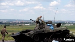 Ukrainian soldiers inspecting a destroyed armored vechicle outside Slovyansk on July 5.