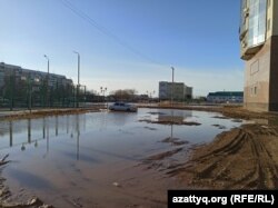 Автомобиль стоит в луже в одном из новых микрорайонов города. Уральск, Западно-Казахстанская область, 31 марта 2021 года.