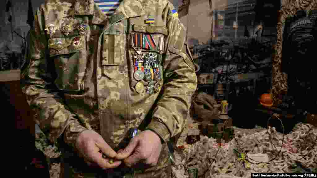 Військовий з нагородами, отриманими в зоні АТО, біля артефактів із Майдану