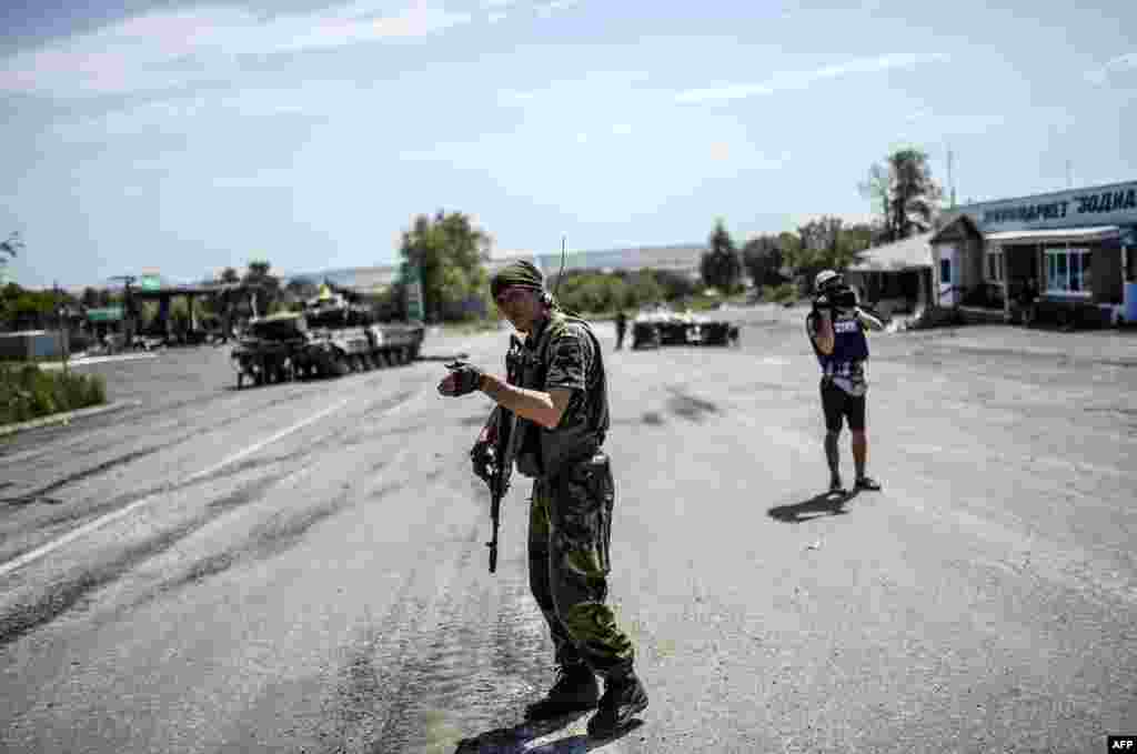 A Ukrainian soldier gestures as he directs traffic at a checkpoint in the village of Debaltseve in the Donetsk region of eastern Ukraine on July 31. (AFP/Bulent Kilic)