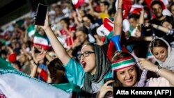 File - Iranian female football fans wave their national flags as they cheer for their national team during a screening of the Russia 2018 World Cup Group B football match between Iran and Spain in Azadi stadium in the capital Tehran, June 20, 2018