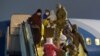 Women and children assisted by Ukrainian personnel disembark from a plane upon their arrival from Syria at an airport outside Kyiv in a photo released on January 1.