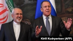 A file photo of Russian Foreign Minister Sergei Lavrov (right) with his Iranian counterpart Mohammad Javad Zarif. Moscow stands poised to capitalize on the probable withdrawal of Western companies from deals with Tehran when the U.S. reintroduces economic sanctions. 