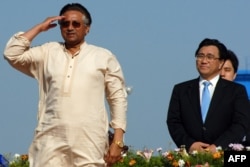 Then-Pakistani President Pervez Musharraf (left) salutes as China's Minister for Communication Li Shenglin (right) looks on during the inauguration of the Gwadar port on March 20, 2007.