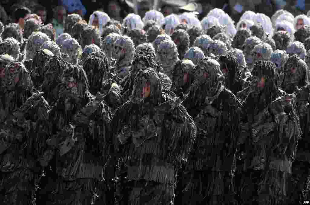 Iranian soldiers wearing ghillie suits, a type of camouflage designed to resemble heavy foliage, march during the annual military parade marking the anniversary of Iran's war with Iraq (1980-88) in Tehran. (AFP/Atta Kenare)