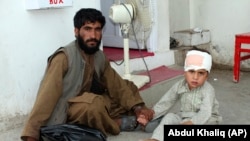 A boy who was injured boy in a deadly attack on a market sits on the ground at a hospital in Helmand Province on June 29.