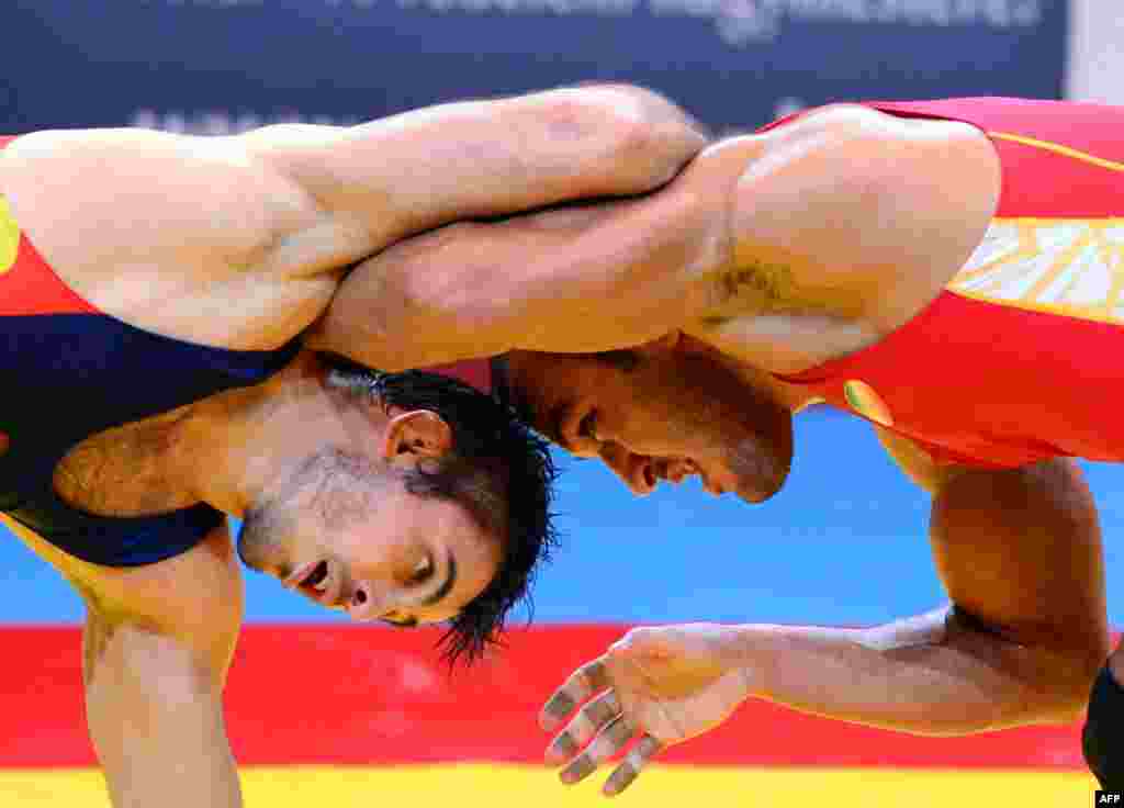 Iran's Ehsan Lashgari (right) fights for the bronze medal with Spain's Talmuraz Friev during the men's freestyle 84-kilogram category at the FILA World Wrestling Championships in Budapest. (AFP/Attila Kisbenedek)