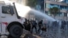 Demonstruesit reagojnë ndaj një topi uji të policisë gjatë protestës antiqeveritare të studentëve në Tiranë, Shqipëri, më 16 tetor 2026.