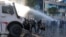 Demonstruesit reagojnë ndaj një topi uji të policisë gjatë protestës antiqeveritare të studentëve në Tiranë, Shqipëri, më 16 tetor 2026.
