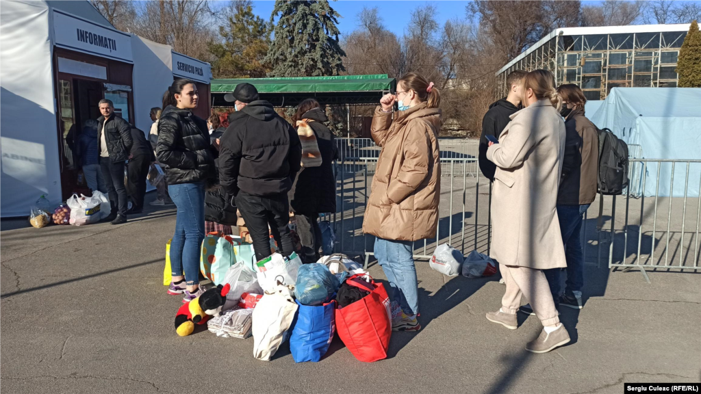 Oamenii stau la coadă pentru a face donații (alimente, haine, obiecte de igienă personală)&nbsp;