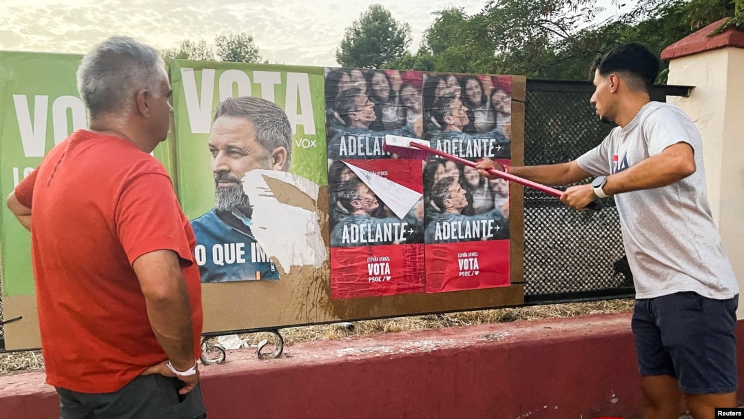 Membrii Partidului Socialist al Muncitorilor lipesc afișe electorale ale premierului interimar și liderului socialist al Spaniei, Pedro Sánchez, lângă un afiș electoral al liderului partidului spaniol de extremă dreapta Vox, Santiago Abascal.