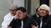 Afghan men cry at a hospital after they heard that their relative was killed during an attack in Kabul on March 6