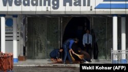 Afghan workers clean the area outside of a wedding hall on November 21 a day after a deadly suicide attack in Kabul.