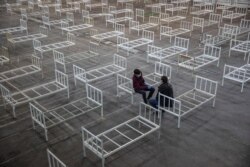 მოხალისეები შესვენებისას სერბეთის ქალაქ ნოვი სადში. ისინი კორონავირუსის მსუბუქი სიმპტომების მქონე პაციენტებისთვის საწოლებს დგამენ ნოვი სადის ბაზრობის ტერიტორიაზე. 27 მარტი.