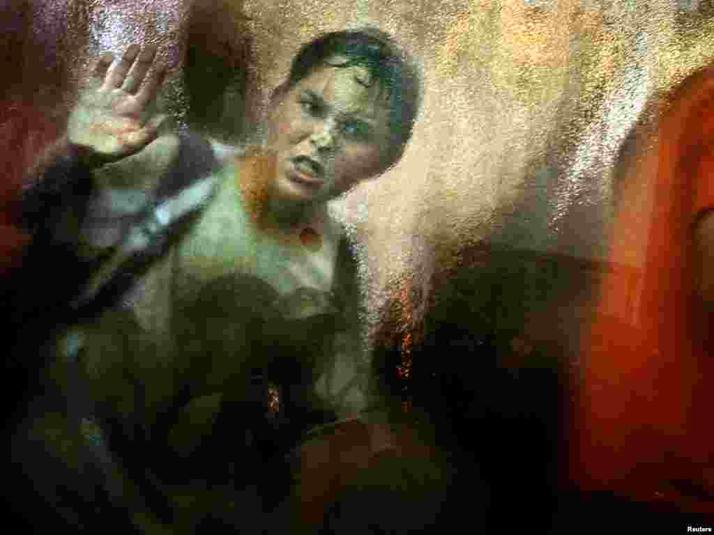 An angry Jewish settler boy looks out from inside a synagogue as Israeli policemen and solider storm inside in the Neve Dekalim settlement in the Gush Katif, August 18, 2005. Israeli troops stormed two Gaza Strip synagogues and dragged out screaming settlers and supporters on Thursday in assaults on the last bastions of resistance to a pullout from the occupied territory. REUTERS/Damir Sagolj