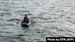 عکس آرشیوی سه پناهجو را سوار بر یک کایاک در اوت سال جاری در کانال مانش نشان می‌دهد
