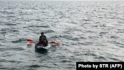 عکس آرشیوی از سه پناهجو سوار بر یک کایاک در سال گذشته در کانال مانش