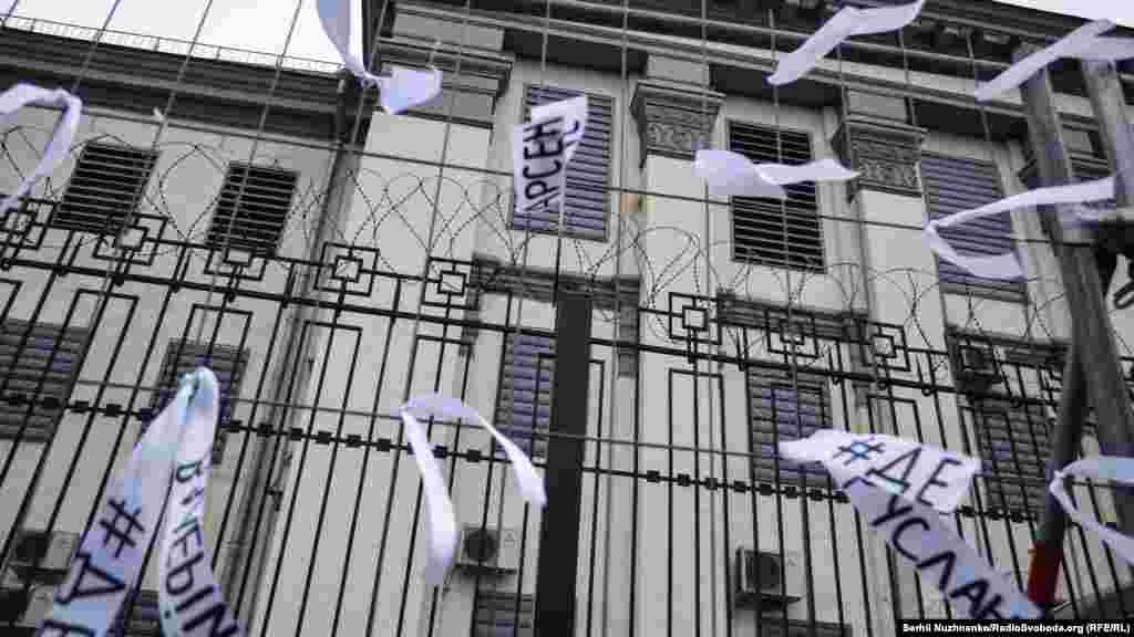Пикетчики привязывают к забору посольства России белые ленты с именами похищенных. Они символизируют надежду на то, что жертвы насильственных исчезновений найдутся