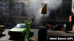 A city worker disinfects a bus stop sign because of the new coronavirus in Tehran, March 5, 2020