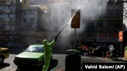  A city worker disinfects a bus stop sign because of the new coronavirus in Tehran, March 5, 2020