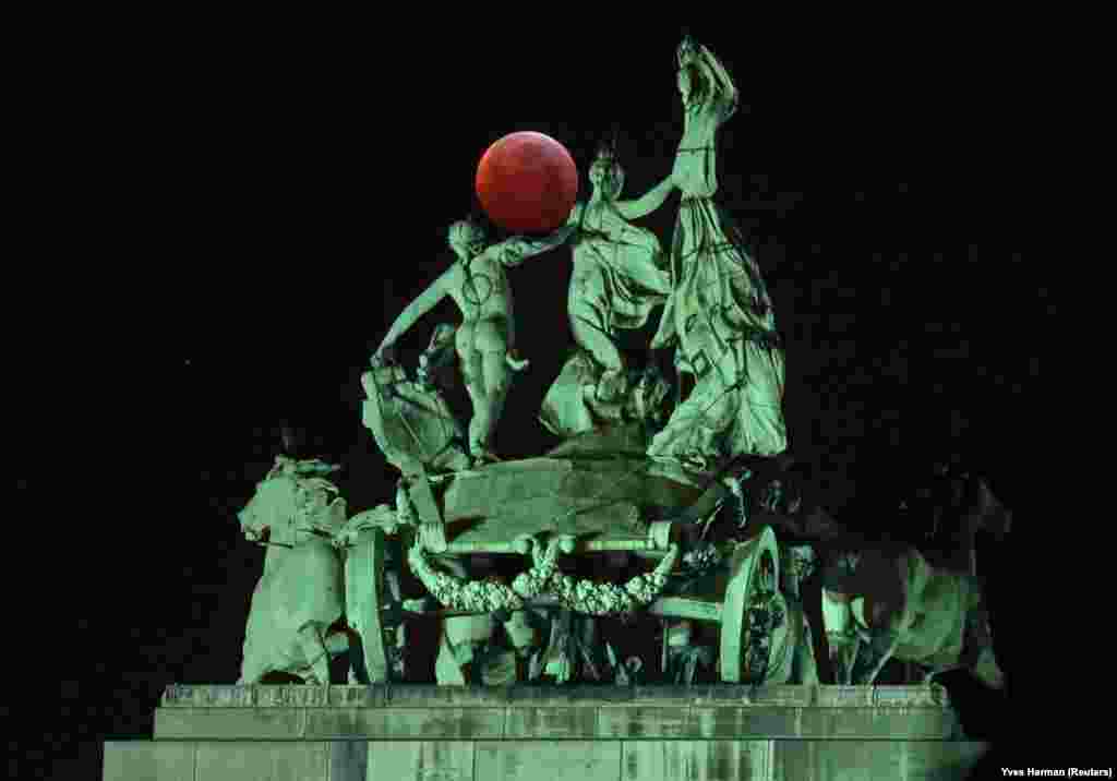 The moon is seen beside a quadriga on the top of the Cinquantenaire arch during a total lunar eclipse, known as the &quot;Super Blood Wolf Moon,&quot; in Brussels on January 21. (Reuters/Yves Herman)