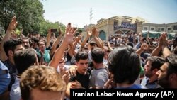 A group of protesters chant slogans at the main gate of old grand bazaar in Tehran, Iran, Monday, June 25, 2018. Protesters in the Iranian capital swarmed its historic Grand Bazaar on Monday, news agencies reported, and forced shopkeepers to close