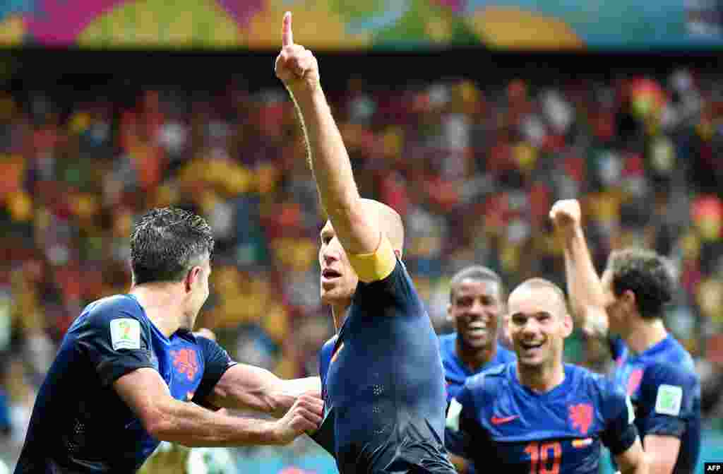 Netherlands' forward Arjen Robben (C) celebrates after his team won a Group B football match between Spain and the Netherlands at the Fonte Nova Arena in Salvador during the 2014 FIFA World Cup on June 13, 2014. AFP PHOTO / DAMIEN MEYER