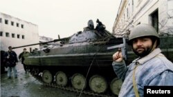 Сторонник Ичкерии осматривает танк российских войск в Грозном. 4 января 1995 года
