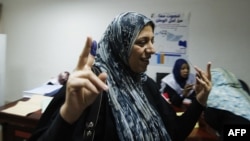 A Libyan woman raises her ink stained finger after voting in Libya's parliamentary elections in Tripoli on July 7. 