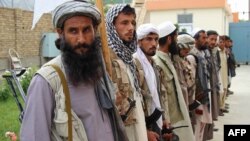 Afghan Taliban militants hand over weapons as part of a government peace-and-reconciliation process at a ceremony in Kunduz on May 6.