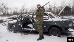 Украинский военный рядом с автомобилем, поврежденным при артиллерийском обстреле. Авдеевка, 7 февраля 2017 года.
