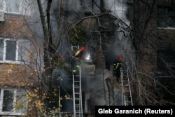Пожарные тушат пожар в жилом доме, пострадавшем от российского удара. Киев, 15 ноября 2022 года