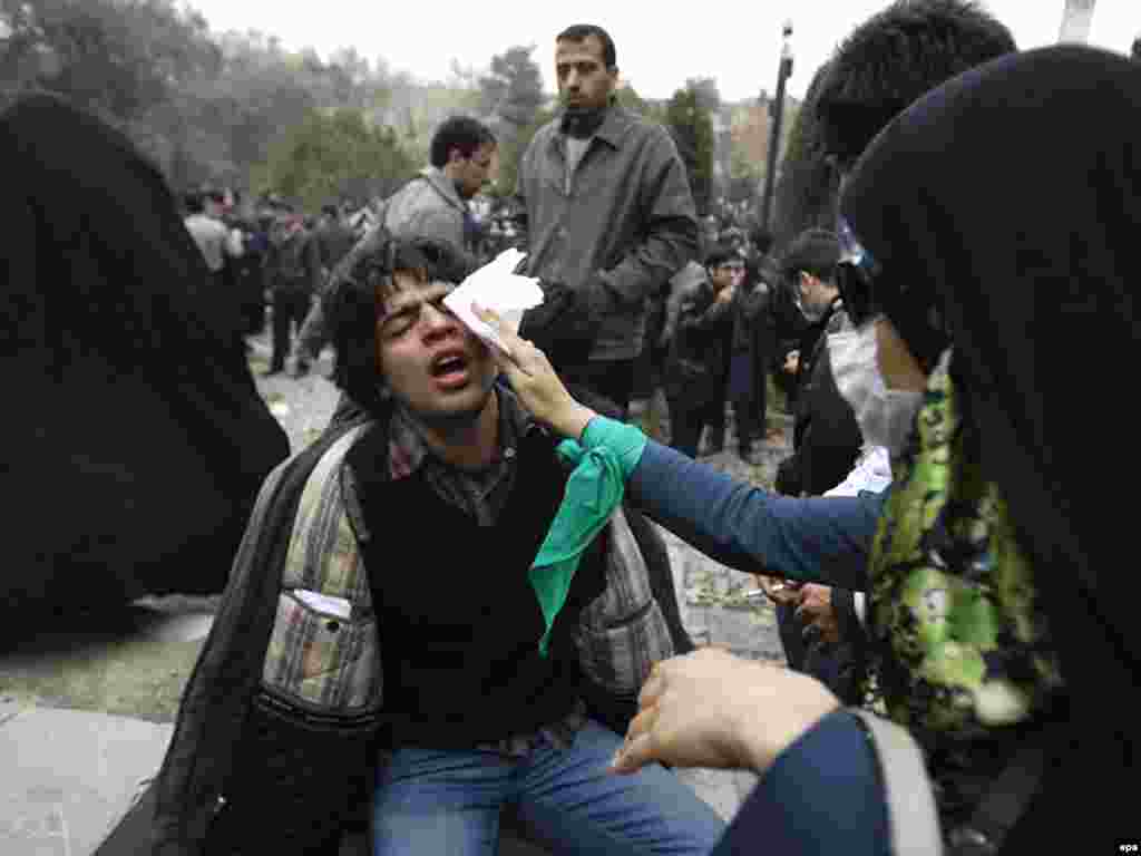 Antigovernment protesters in Tehran help a man injured during a clash with police. - Iranian security forces used batons and tear gas to disperse opposition protesters on December 7. Photo by epa