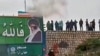 A screen grab from a video taken earlier this month that apparently shows protesters throwing a small explosive device at a banner depicting the Islamic republic's Supreme Leader Ayatollah Ali Khamenei in the central city of Isfahan. 