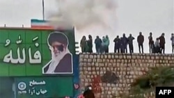 A screen-grab from a video taken earlier this month that apparently shows protesters throwing a small explosive device at a banner depicting the Islamic republic's Supreme Leader Ayatollah Ali Khamenei in the central city of Isfahan. 