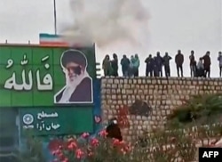 Протестующие кидают камни в изображение Верховного лидера Ирана Али Хаменеи. Город Исфахан, 3 ноября 2022 года. Фото из соцсетей