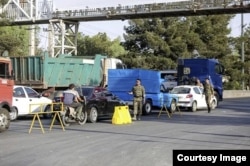 Security forces inspect vehicles at a checkpoint in Iran.