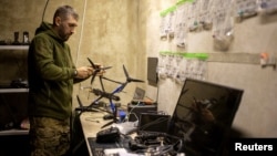 Старший сержант 7-го корпусу швидкого реагування Десантно-штурмових військ працює над дроном перед відправкою на Покровський напрямок, листопад 2025 року