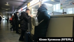 Passengers wait at service desks at St. Petersburg's Pulkovo airport. (file photo)