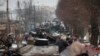 Ljudi gledaju ostatke ruskih vojnih vozila na putu u gradu Buča, u blizini glavnog grada Kijeva, Ukrajina, u utorak, 1. marta 2022.