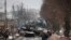 شهروندان اوکراینی در حال نظاره بقایای خودروهای نظامی روسی در جاده‌ای در شهر بوچا، حومه پایتخت اوکراین- یکم مارس ۲۰۲۲