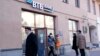 People stand in line to withdraw money from an ATM of VTB Bank in downtown Moscow on February 28.