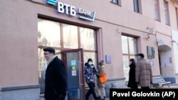 People stand in line to withdraw money from an ATM of VTB Bank in downtown Moscow on February 28.