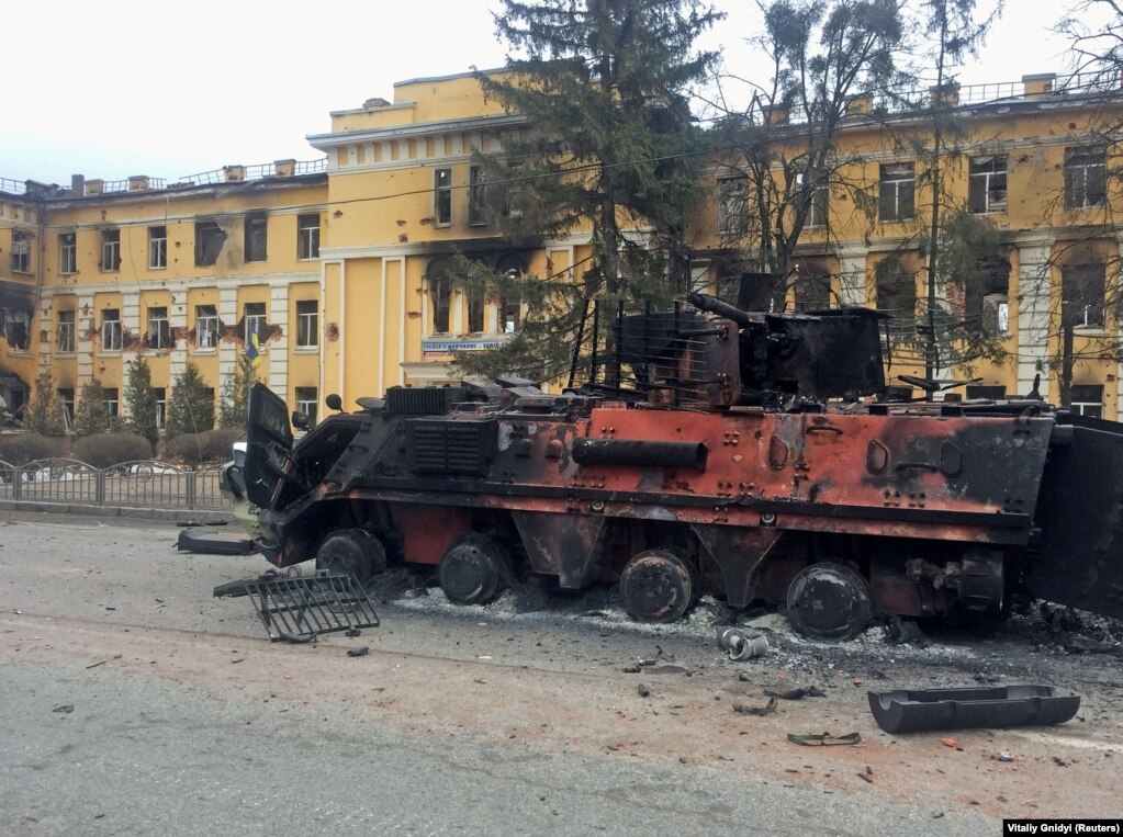 Знищений український БТР перед школою, яка, за словами місцевих жителів, горіла після обстрілу з боку Росії. Фото від 28 лютого 2022 року