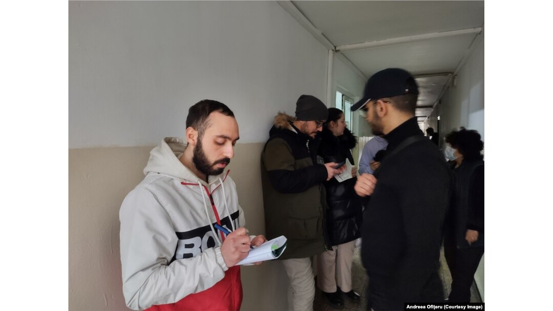 Unul dintre studenții tunisieni, Abderrazel Ayari, notează numărul de telefon pentru că vrea să obțină mai multe informații despre cum poate să rămână în România.