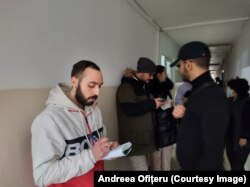 Unul dintre studenții tunisieni, Abderrazel Ayari, notează numărul de telefon pentru că vrea să obțină mai multe informații despre cum poate să rămână în România.