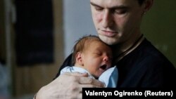 Батько з новонародженою дитиною в укритті перинатального центру, Київ, 2 березня 2022 року