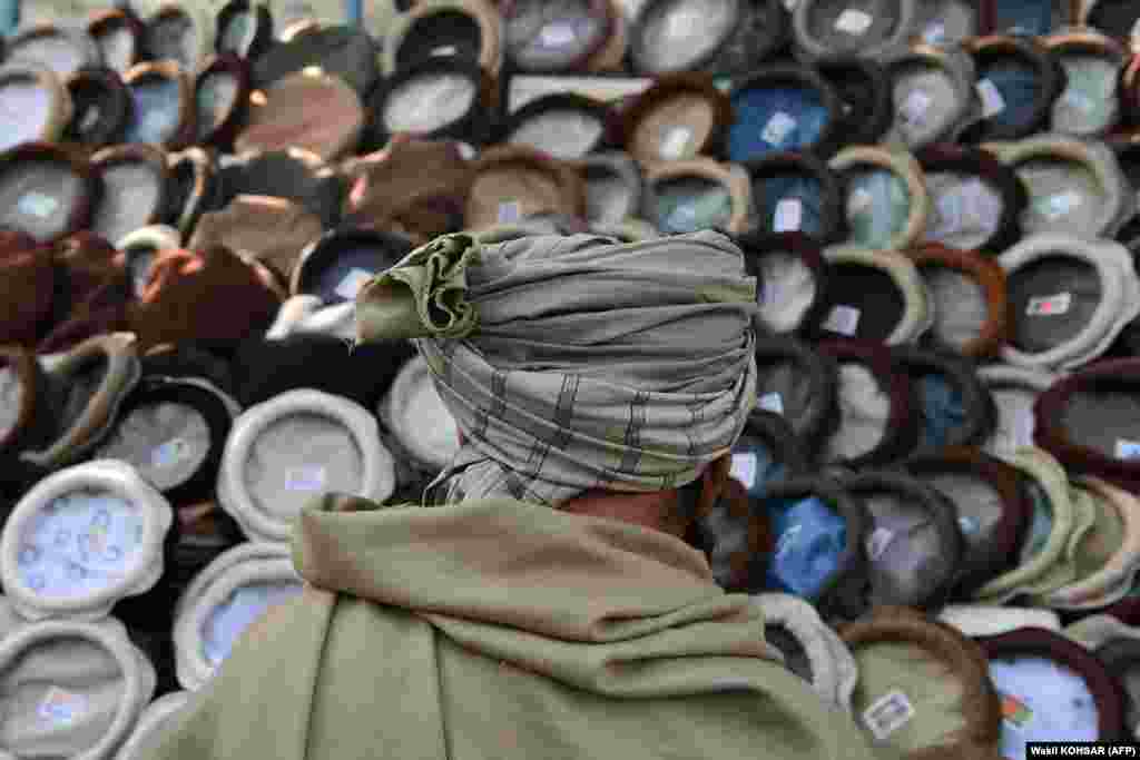 An Afghan man looks at hats in a market near the Pul-e Khishti mosque in Kabul.&nbsp;
